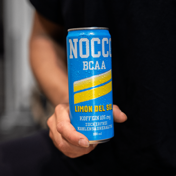 Hand hält eine blaue Dose NOCCO BCAA Limón Del Sol.