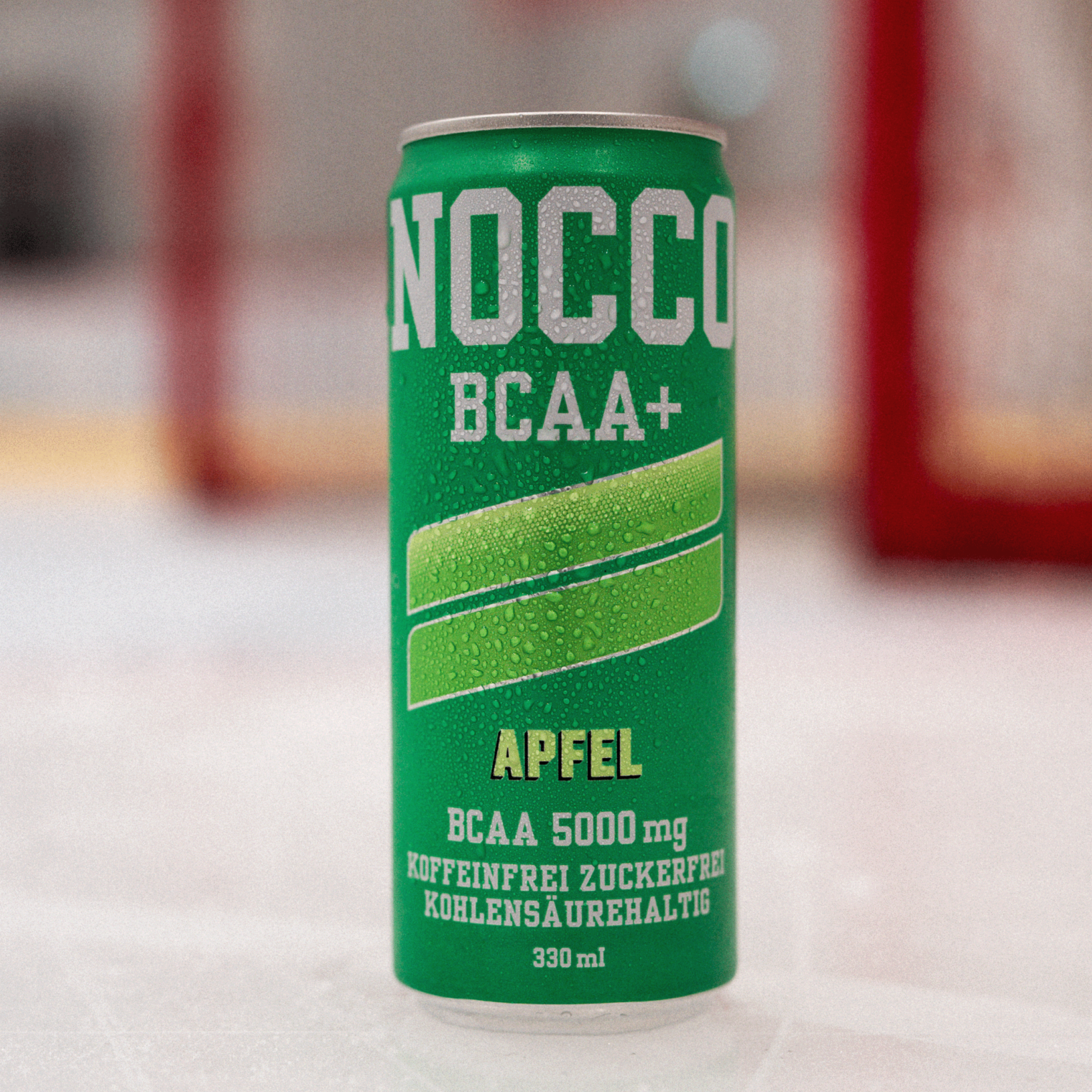 Grüne Getränkedose mit Aufschrift "NOCCO BCAA+" und Apfelgeschmack, kondenswasserbedeckt.